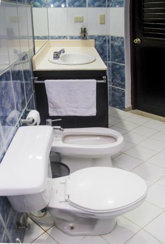 a bathroom with two toilets and a sink at Cita del Sol City Apartments in Cabarete