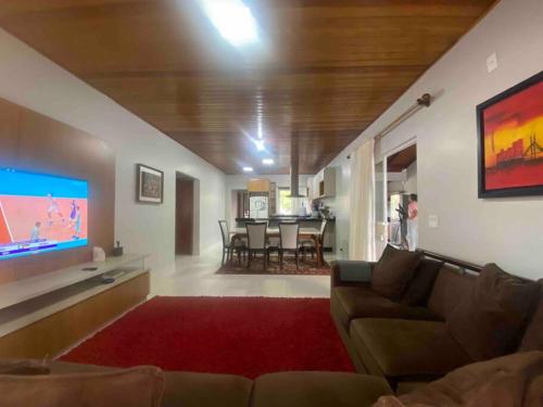 a living room with a couch and a flat screen tv at Casa de praia aconchegante in Barra Velha