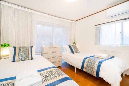 Un dormitorio con dos camas y una ventana en 春5GWifi TokyoDome皇居1km〜 RoofGarden 上野秋葉原銀座東京2km～都心, en Tokio