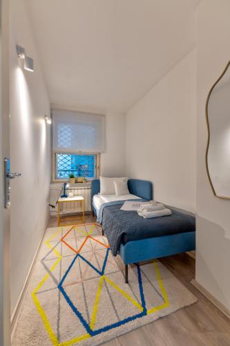 a bedroom with a bed and a rug on a floor at ZIGZAG Belgrade in Belgrade