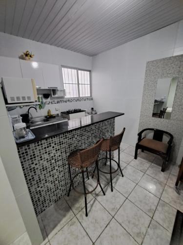 a kitchen with two chairs and a counter top at Aconchegante Apto de 1qt a 60mts do Consulado EUA in Recife