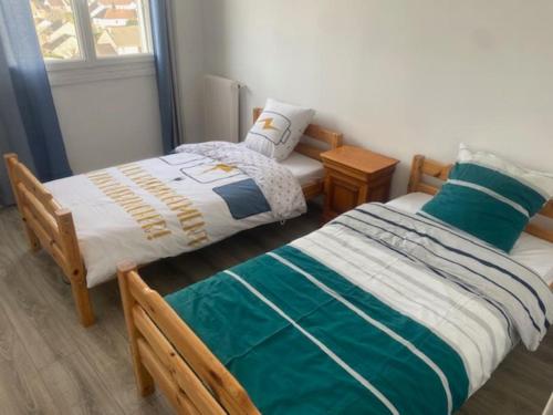 zwei Betten nebeneinander in einem Zimmer in der Unterkunft Kennedy in Saint-Jean-de-Braye