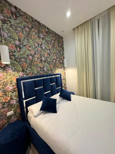 a bedroom with a bed with a floral wall at Eden LUXURY ROMA in Rome