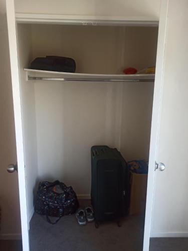 a room with a closet with a backpack and shoes at 10 Tapuwae in Auckland