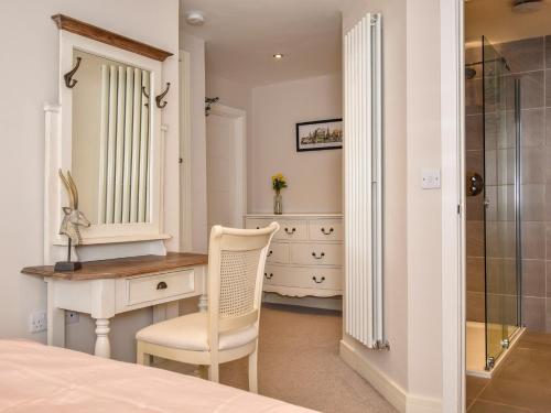 a bedroom with a desk and a chair next to a dresser at 1 Bed in Rothbury 88286 in Rothbury