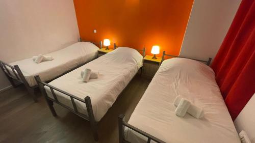 2 camas individuales en una habitación con 2 lámparas en Hôtel Le Saint Quentin en Saint-Quentin