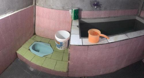 uma casa de banho com um WC e uma lata de lixo em ORA KOMODO HOME STAY em Komodo