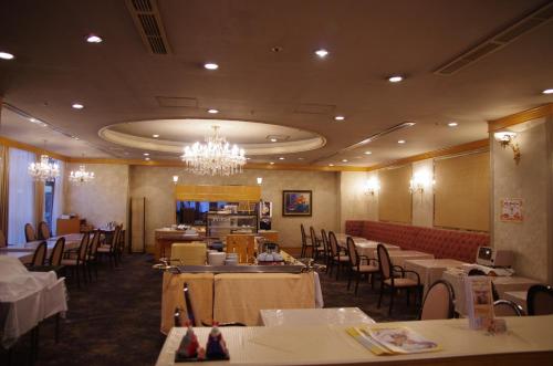 a dining room with tables and chairs and a chandelier at Gifu Castle Inn in Gifu