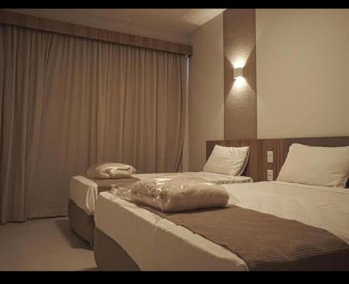 ein Hotelzimmer mit 2 Betten und einem Fenster in der Unterkunft Praias do Lago Ecoresort in Caldas Novas