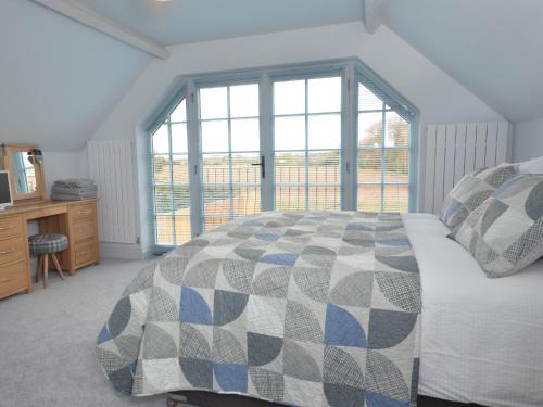 a bedroom with a bed and a large window at 3 Bed in Cromer 47832 in Northrepps