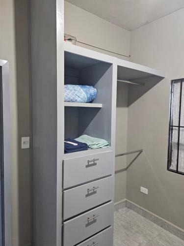 a walk in closet with white cabinets and drawers at Departamento madroño in Matamoros