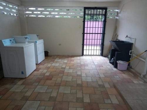 an empty room with a door and a tile floor at Close to Everything in Port-of-Spain