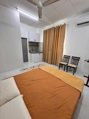a large bed in a room with a couch and chairs at MHI Homestay Bandar Baru Jelawat in Bachok