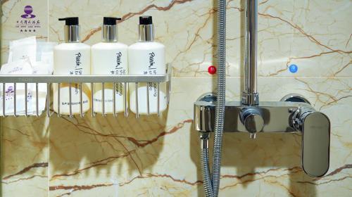 a group of four shampoo bottles on a bathroom counter at Sun Moon Lake Hotel Dalian大连火车站店 in Dalian