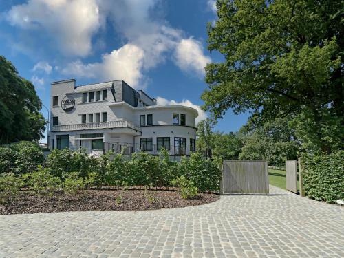 a large white house with a driveway at Villa Col 38 in Buisestraat