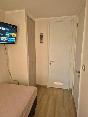 a room with a bed and a flat screen tv at Habitación con Baño Privado en Depto Compartido in Santiago