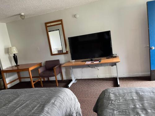 a room with a desk with a tv and a desk sidx sidx sidx at Royal A Motel in Auburn