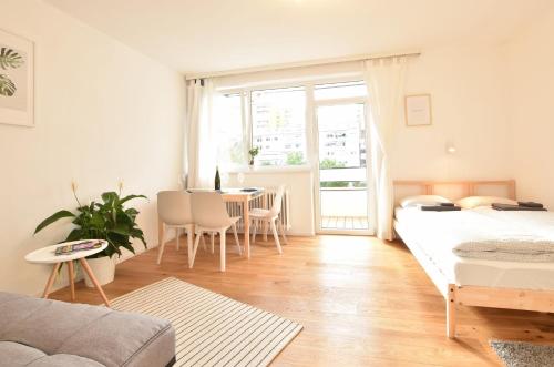 ein Wohnzimmer mit einem Bett und einem Tisch mit Stühlen in der Unterkunft Peaceful Studio Apartment near Center in Innsbruck