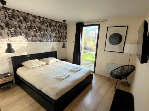 a bedroom with a bed with two towels on it at Villa en bois à la campagne - 20 min de Rouen in Morgny-la-Pommeraye