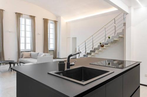 a kitchen with a sink and a living room at Diaz Novantuno - Luxury Apartments Como City Center in Como