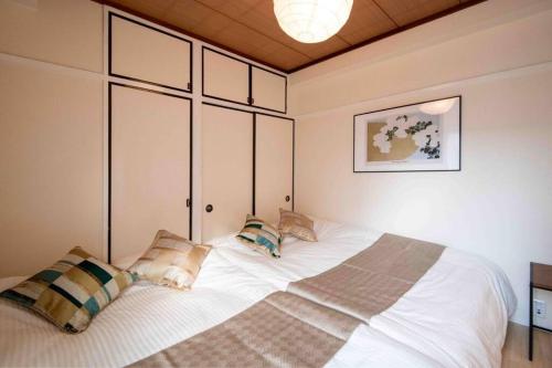 1 dormitorio con 1 cama blanca grande con almohadas en FIKA ASAKUSA, en Tokio