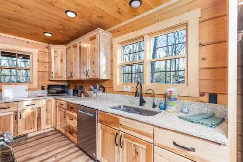 a kitchen with wooden cabinets and a sink at Stunning Sevierville Cabin: Hot Tub w/ View in Sevierville