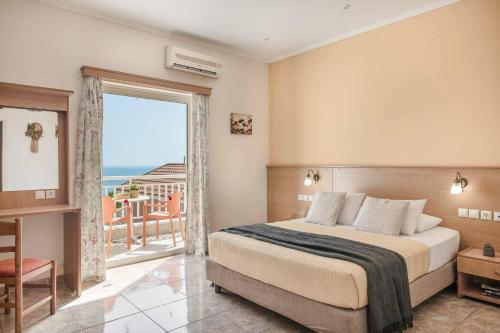 a bedroom with a bed and a view of the ocean at Villa Angeliki Skala in Spathíon
