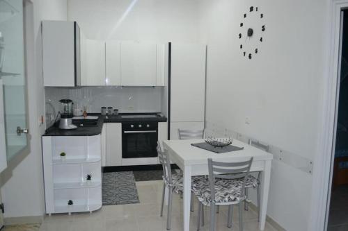 uma cozinha branca com uma mesa e cadeiras brancas em Horizon em Castel San Giorgio