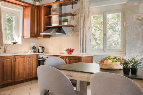 a kitchen with a table with chairs and a bowl of fruit at Evanthia by Vintage Travel in Fiskardho