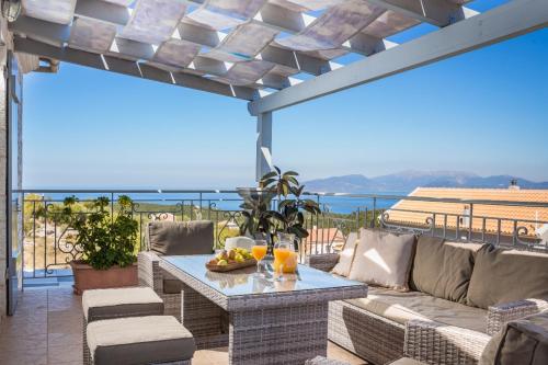 a patio with a couch and a table with fruit on it at Evanthia by Vintage Travel in Fiskardho
