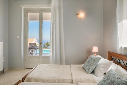 a bedroom with a bed with a view of the ocean at Evanthia by Vintage Travel in Fiskardo