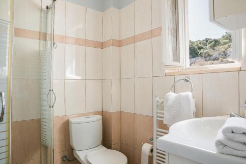 a bathroom with a toilet and a sink at Evanthia by Vintage Travel in Fiskardo
