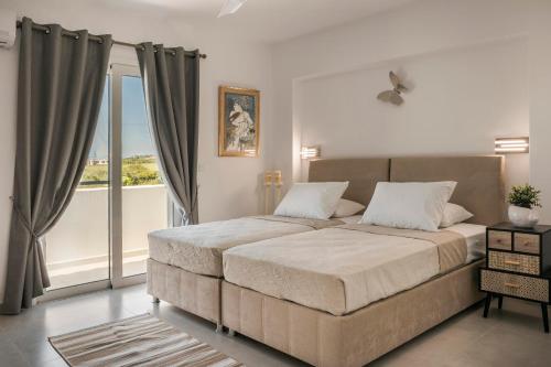 a bedroom with a large bed and a balcony at Ai Helis Summer House by Vintage Travel in Svoronata