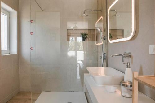a white bathroom with a sink and a shower at Ai Helis Summer House by Vintage Travel in Svoronata