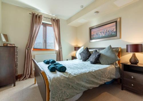 Un dormitorio con una cama con toallas azules. en 14 Neptune House en Milford Haven