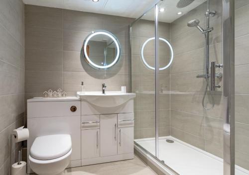 a bathroom with a toilet and a sink and a shower at 14 Neptune House in Milford Haven