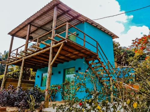 a blue house with a wooden roof at Flat Noronha Dreams in Fernando de Noronha