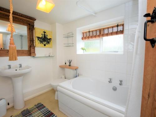 een badkamer met een bad, een toilet en een wastafel bij 2 Bed in St Neots 62322 in Wyboston