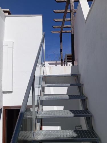 a staircase leading up to a building with a blue sky at Amapola Alojamiento Rural in Zuheros