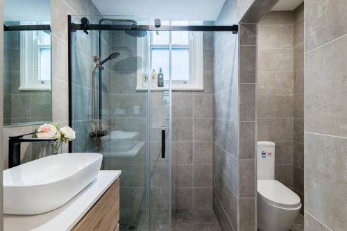 ein Bad mit einer Dusche, einem Waschbecken und einem WC in der Unterkunft Waterfront - KING Bed Master @ Rocks Sydney #9A in Sydney