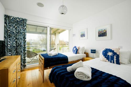 a bedroom with two beds and a window at Lakeside property with spa on a nature reserve Bryony HM35 in Somerford Keynes
