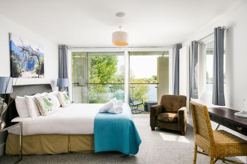 um quarto com uma cama, uma secretária e uma cadeira em Lakeside property with spa access on a nature reserve Keel House CW23 em Somerford Keynes