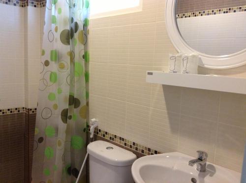 een badkamer met een toilet, een wastafel en een spiegel bij Ban Krut Resort in Ban Krut