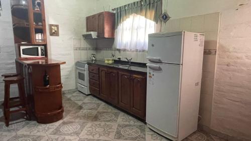eine Küche mit Kühlschrank und Spüle in der Unterkunft Aires del Oeste - Casa de Descanso in Villa Unión