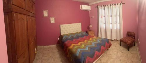 ein Schlafzimmer mit einem farbenfrohen Bett in einem Zimmer in der Unterkunft Aires del Oeste - Casa de Descanso in Villa Unión