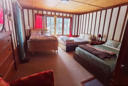 a small room with two beds and a window at Large Lodge at Rainier Lodge (0.4 miles from entrance) in Ashford