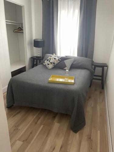 Un dormitorio con una cama y una bandeja. en 4 Pièces, stationnement et tennis en Saguenay