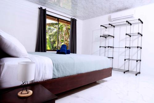 a bedroom with a large bed and a window at Blu House Nature & Tours in Chachagua
