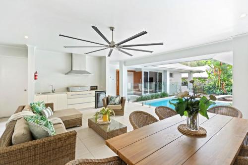 a dining room and living room with a ceiling fan at Belle Escapes - Namaste, Oasis in Palm Cove in Palm Cove
