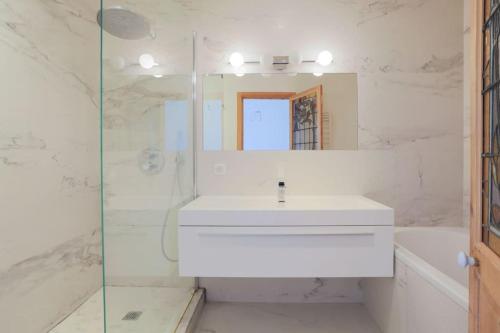 une salle de bain blanche avec un lavabo et un miroir dans l'établissement Amazing Flat Views Seine River, à Paris